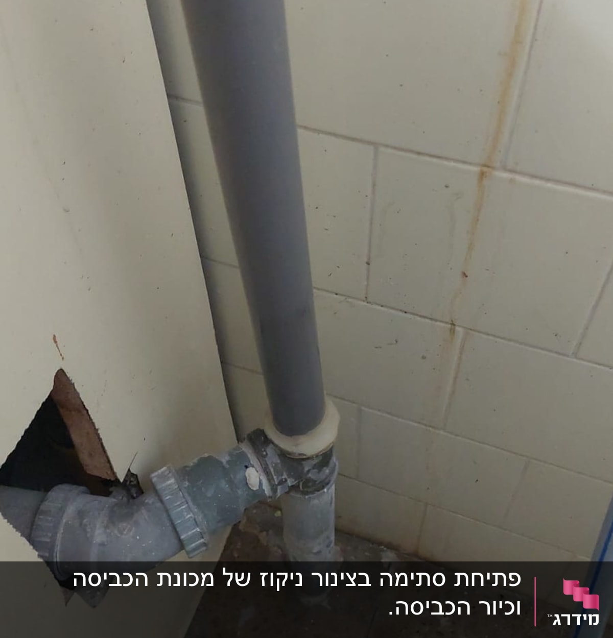 צינור פלסטיק אפור מחובר לקיר אריחים